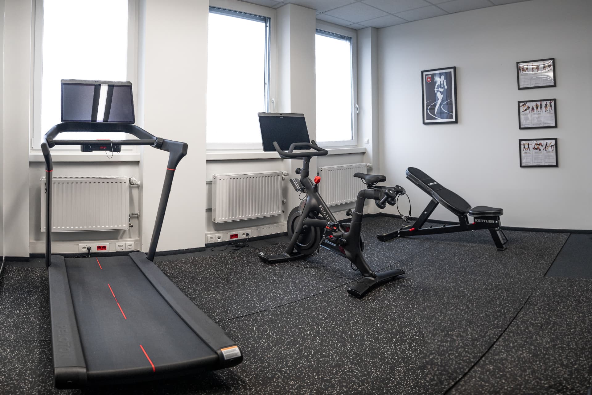 Fitnessraum der Kanzlei mit Laufband, Indoor-Bike und Hantelbank